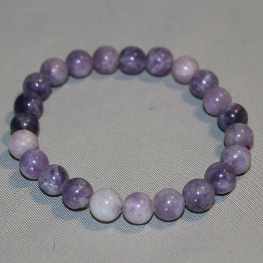 A soothing Lepidolite crystal in soft lavender and purple hues, radiating calming energy—ideal for promoting emotional balance, healing, and peaceful transitions.