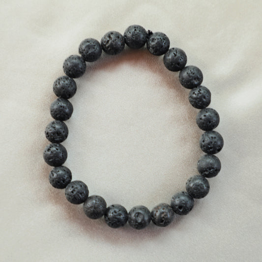 Rough, black Lava Stone crystals with a porous, matte texture, symbolizing strength, grounding, and inner transformation.