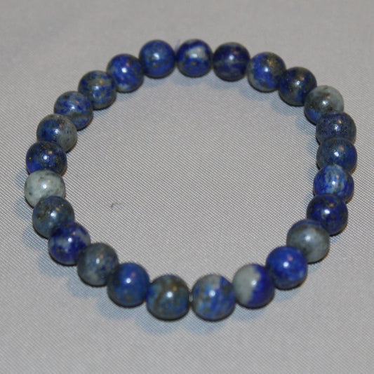 A polished Lapis Lazuli crystal displaying deep royal blue tones with golden pyrite flecks, symbolizing wisdom, truth, and spiritual insight.