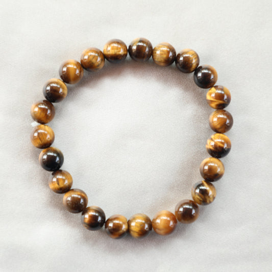 Tiger’s Eye crystal with golden-brown bands, symbolizing courage, protection, and confidence; a grounding stone often used for empowerment and mental clarity.