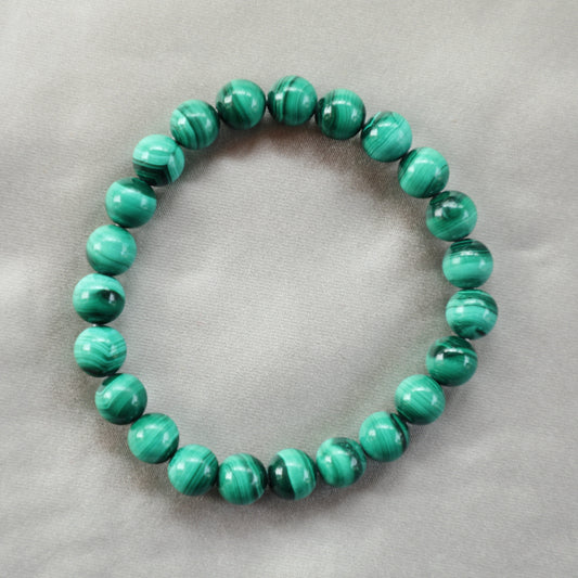 Polished Malachite crystal with vibrant green swirls, symbolizing emotional healing, protection, and transformation.
