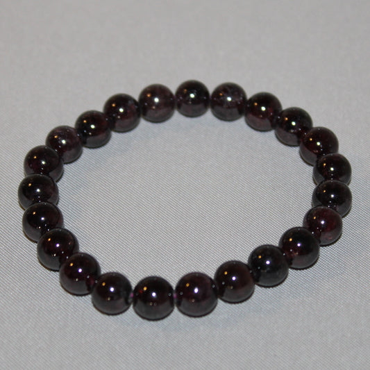 Deep red Garnet crystal glowing with rich, fiery energy, symbolizing passion, strength, and grounding.