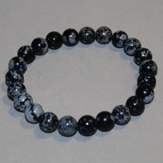 Polished Snowflake Obsidian crystal with natural black and white snowflake-like patterns, symbolizing balance, transformation, and emotional clarity.