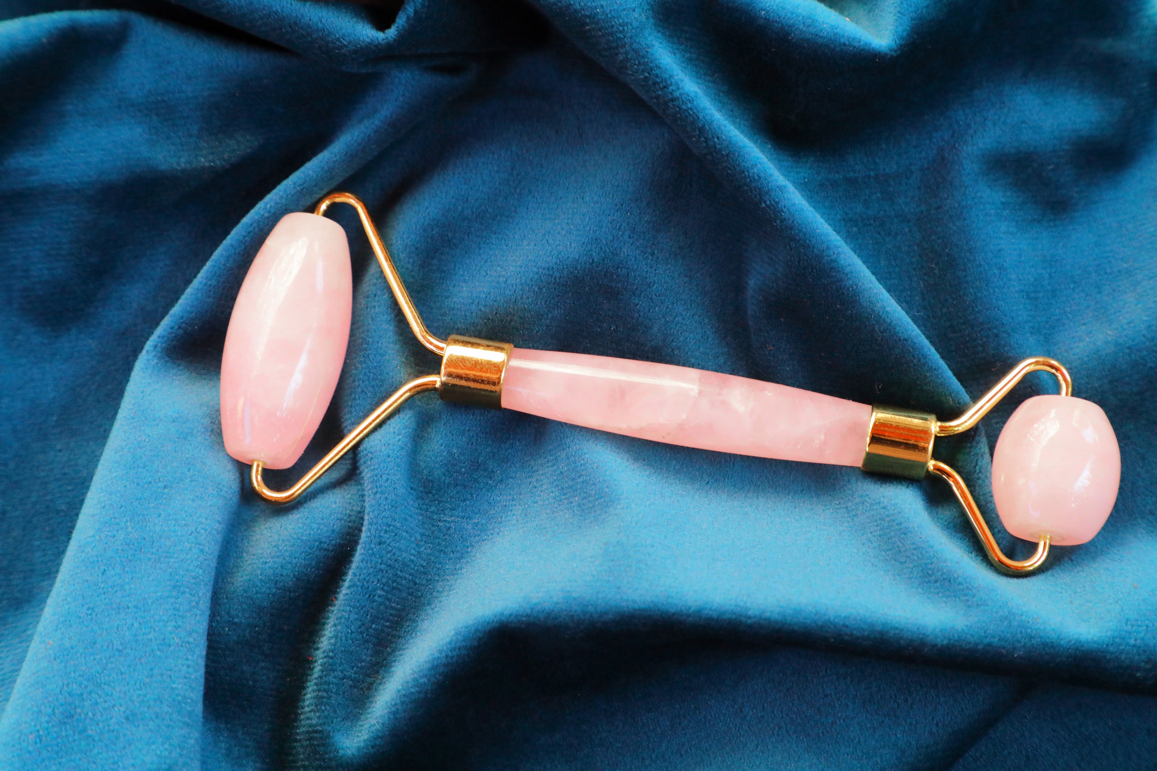 Rose Quartz crystal facial roller with smooth pink stone, used for skincare, self-love rituals, and promoting glowing skin, emotional healing, and Heart Chakra balance.