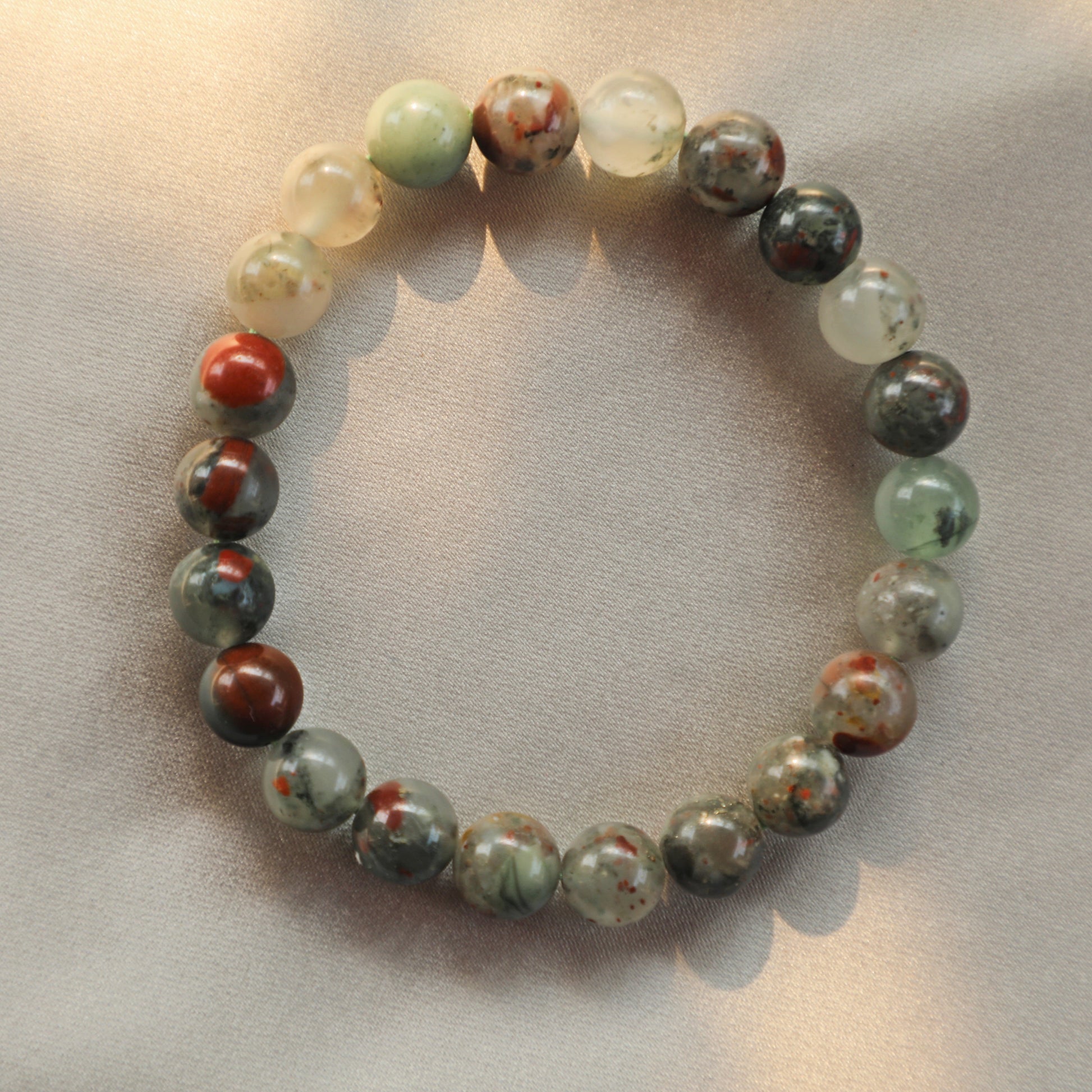 Embrace the mystical energy of the Dragonblood Jasper bracelet, a stunning piece that showcases the unique marbled patterns of deep green and rich red hues. Each bead reflects the stone's natural beauty, symbolizing strength, courage, and vitality. Perfectly polished and strung on a durable elastic band, this bracelet not only adds a touch of elegance to any outfit but also serves as a powerful talisman for grounding and emotional balance.