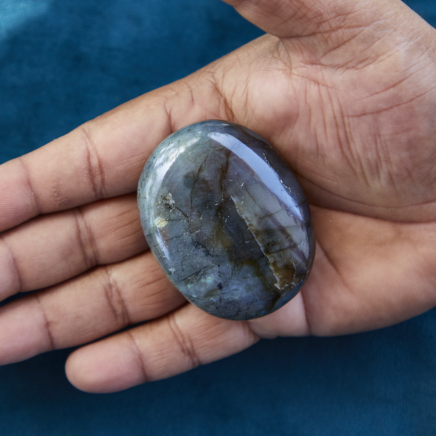 Labradorite crystal with vibrant iridescent flashes of blue and green, symbolizing transformation, intuition, and spiritual protection.