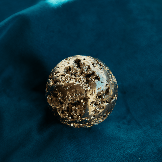 Pyrite crystal with a metallic golden sheen, symbolizing abundance, protection, and confidence. Ideal for enhancing willpower and grounding energy