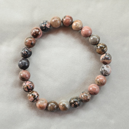 Rhodonite crystal with natural pink and black hues, symbolizing emotional healing, compassion, and heart chakra alignment.